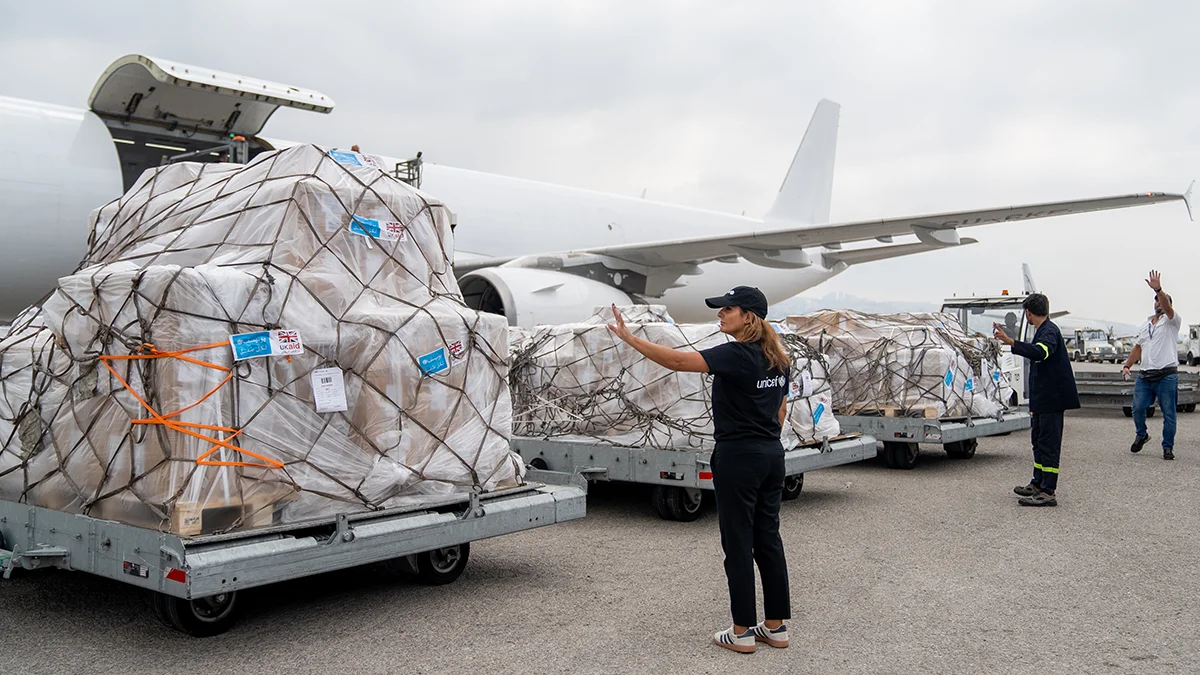 UNICEF Hilfslieferungen stehen vor einem Flugzeug.