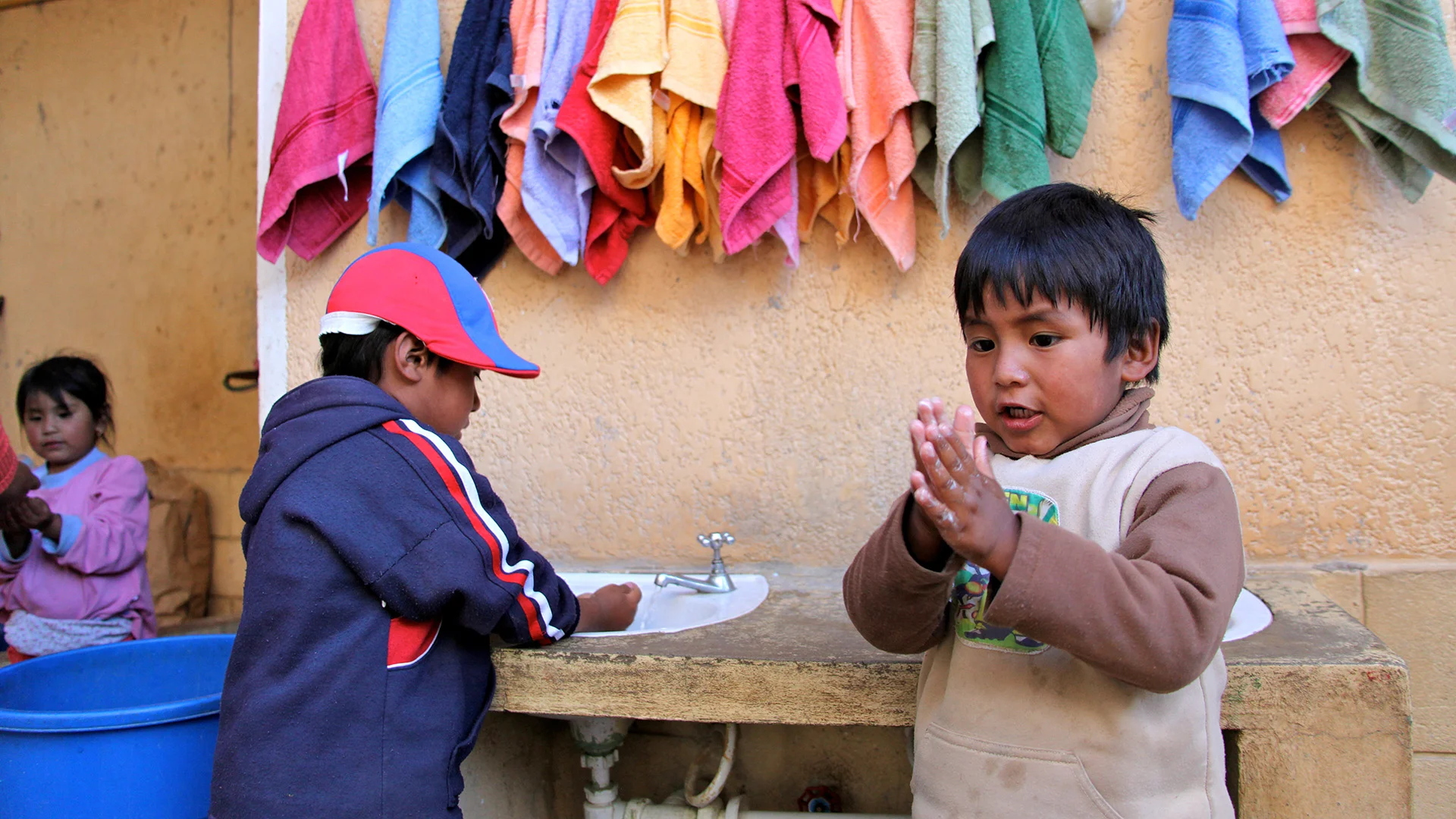 Ein Junge in Bolivien wäscht sich dir Hände.