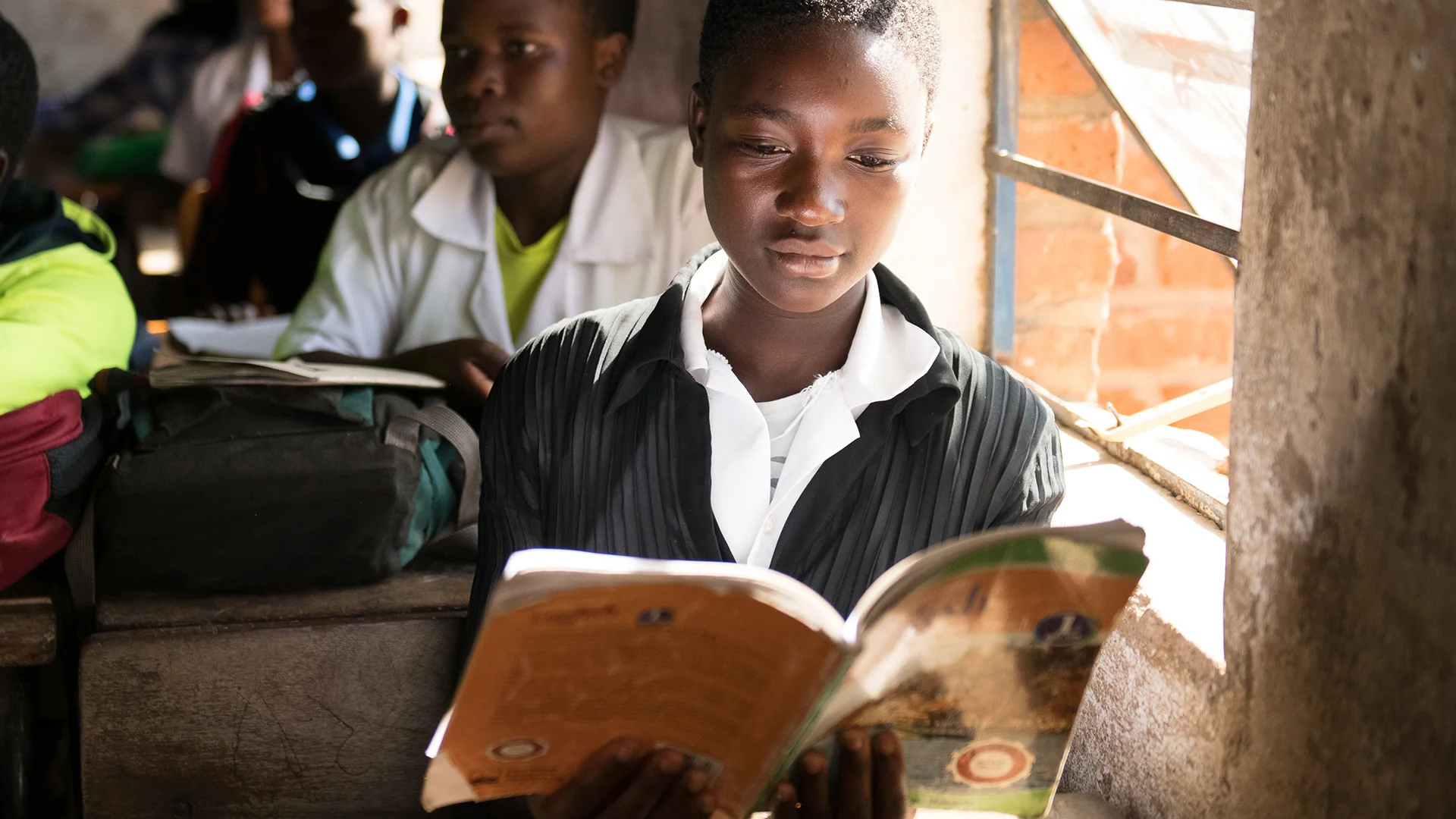 Eine Schülerin aus Malawi liest aufmerksam ihr Schulheft.