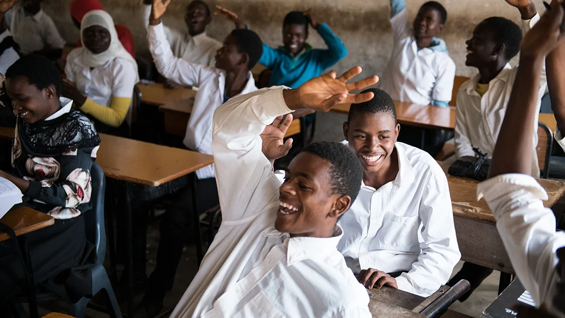 Schüler in einem Klassenzimmer in Malawi lachen vor Freude.